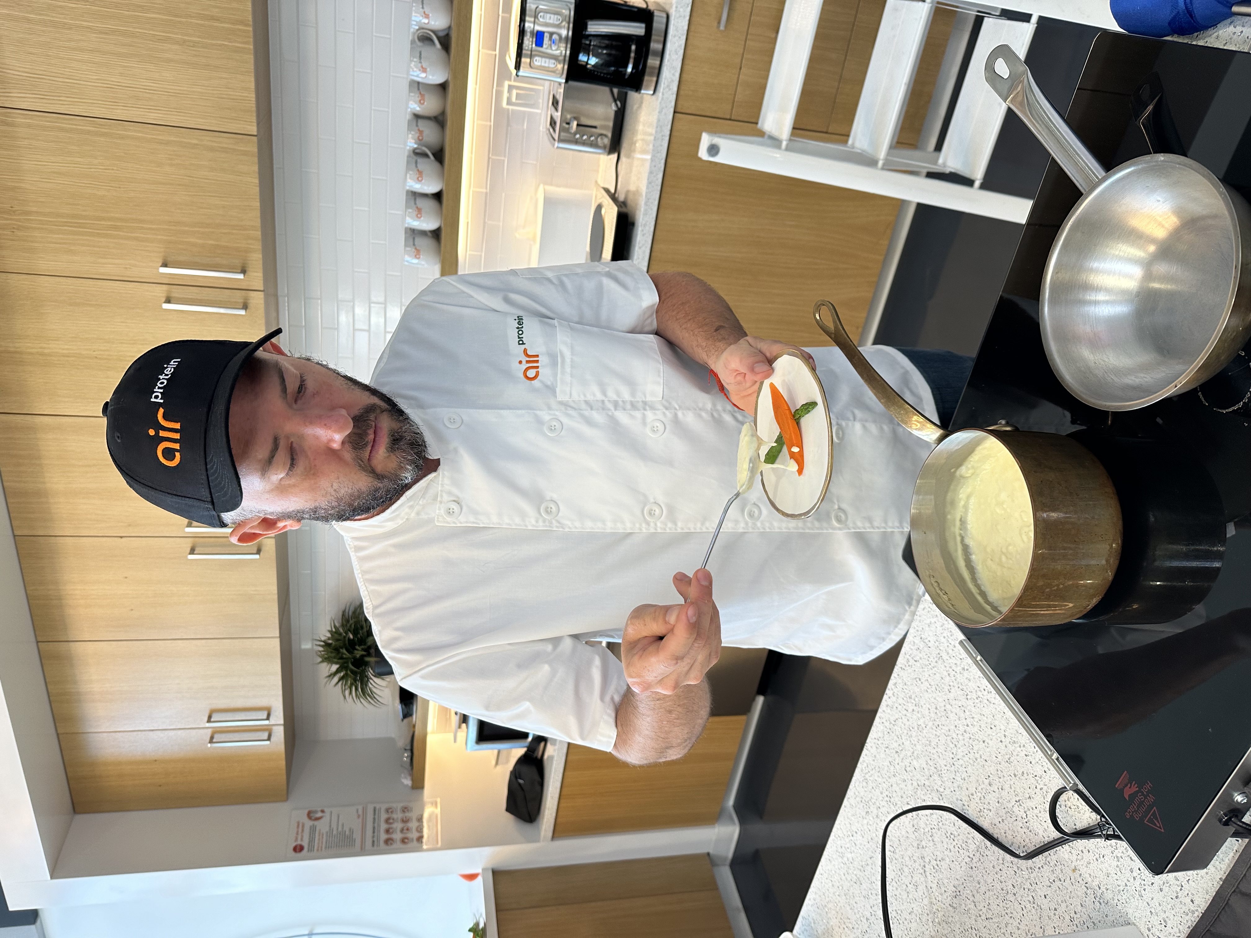 Air Protein chef plating a dish in professional kitchen