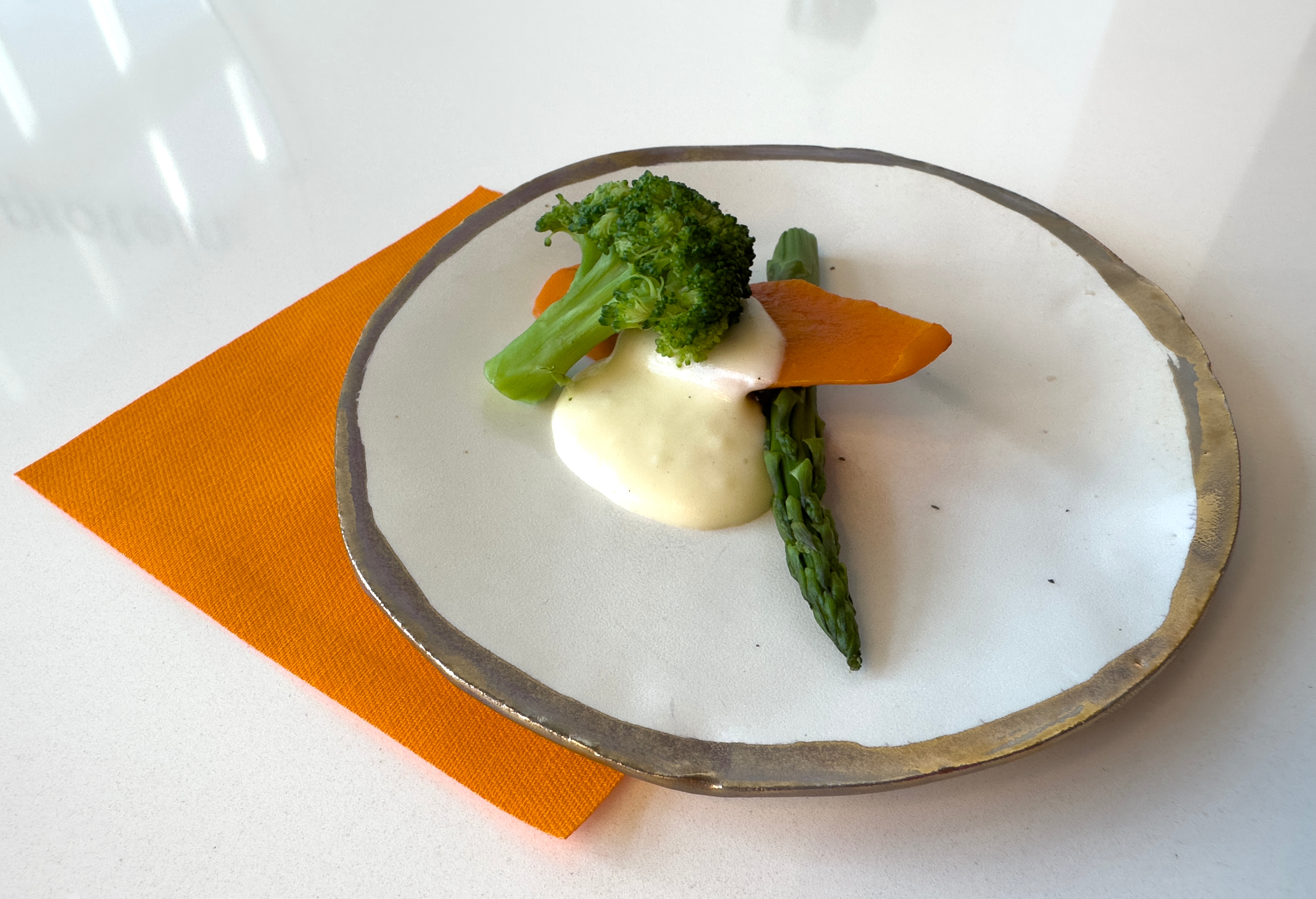 Fresh vegetables with creamy sauce on artisan plate